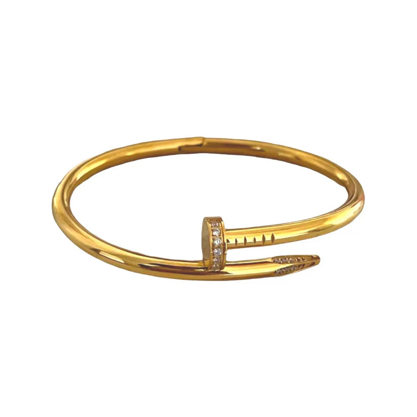 A gold-colored stainless steel bangle bracelet with a nail design.
