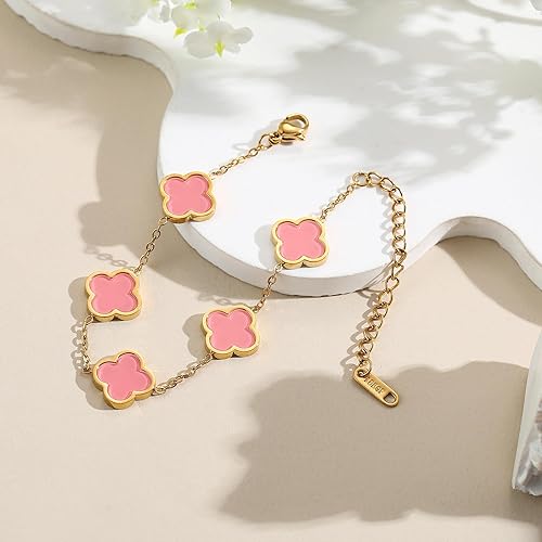 Gold bracelet with pink clover-shaped charms on a white surface