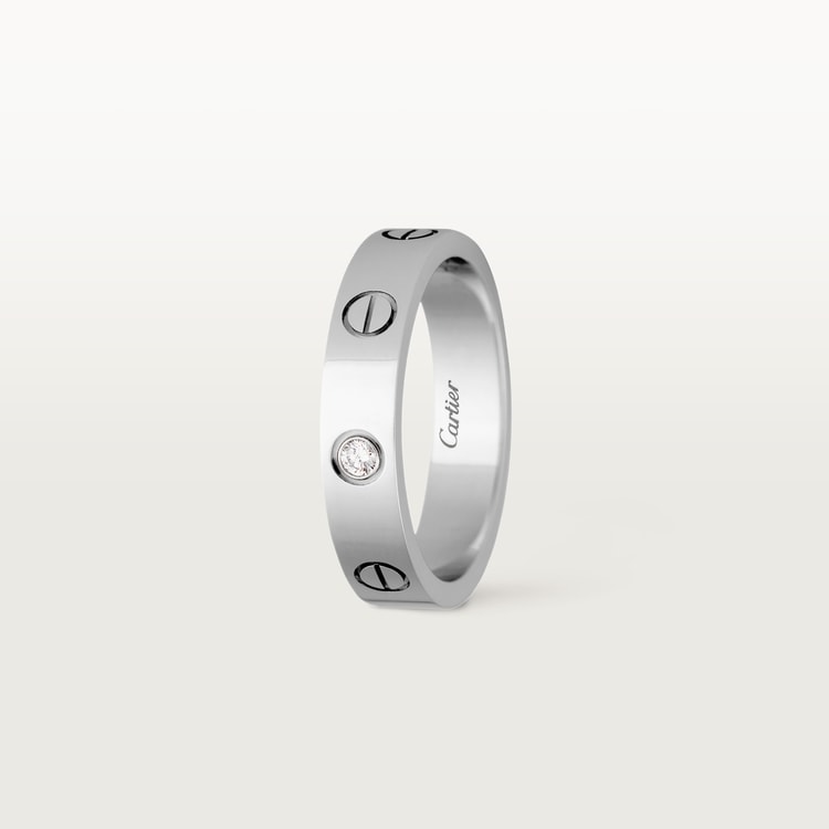 Silver ring with Cartier branding on a white background