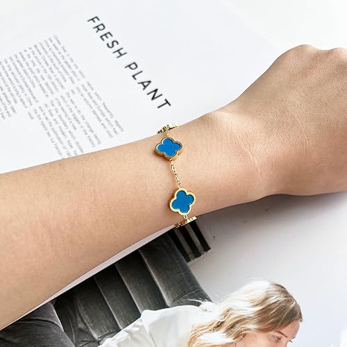 Bracelet with blue clover-shaped charms on a wrist, with a magazine in the background.