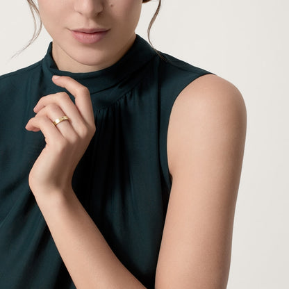 Woman wearing a dark green sleeveless top against a neutral background