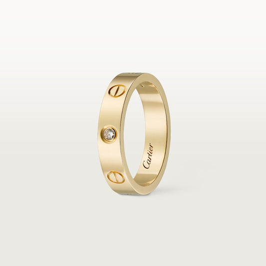Gold ring with a diamond on a light gray background