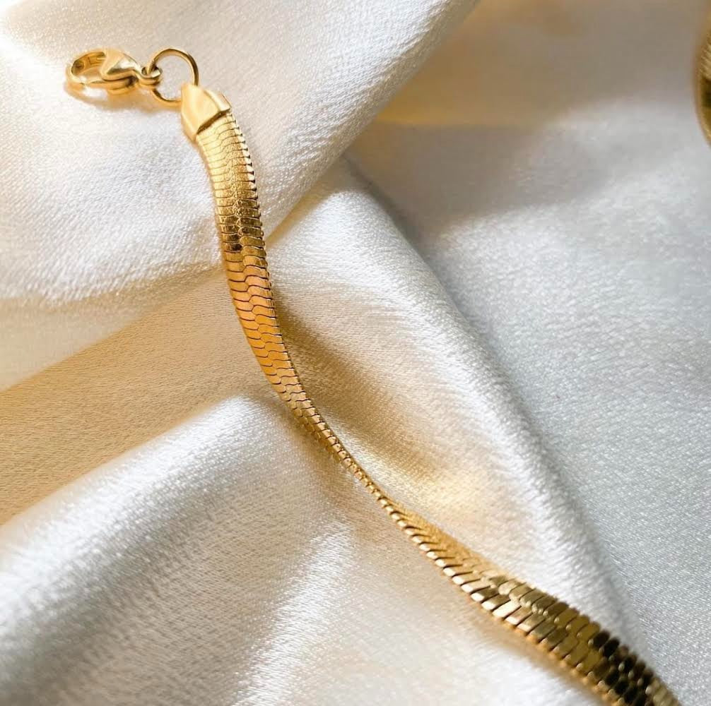 Gold bracelet on a soft fabric background