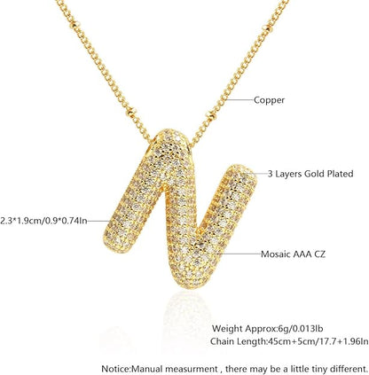 Gold necklace with 'N' pendant featuring technical details on a white background