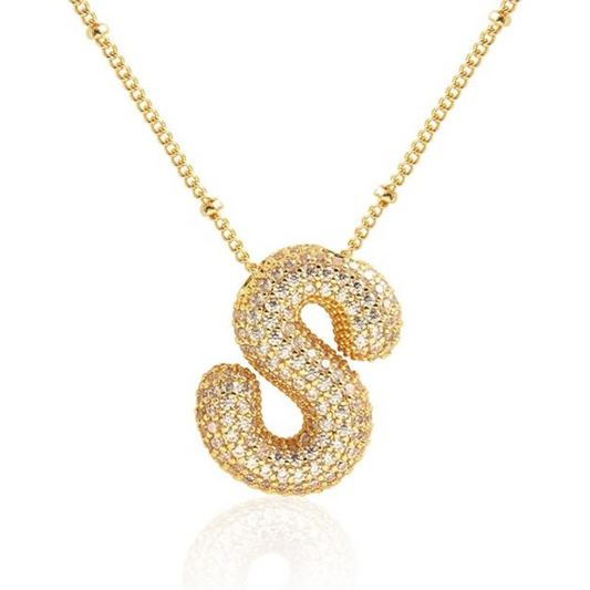 Gold necklace with a letter 'S' pendant on a white background