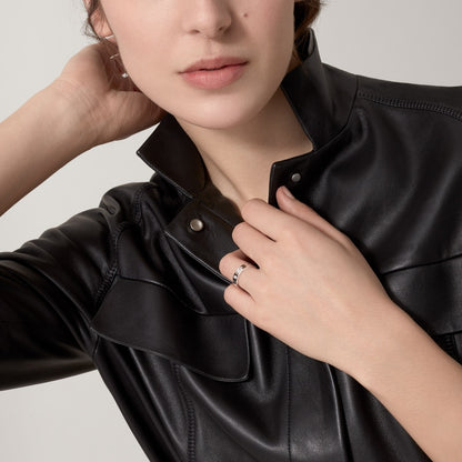 Person wearing a black leather jacket with a neutral background