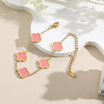Gold bracelet with pink clover-shaped charms on a white surface