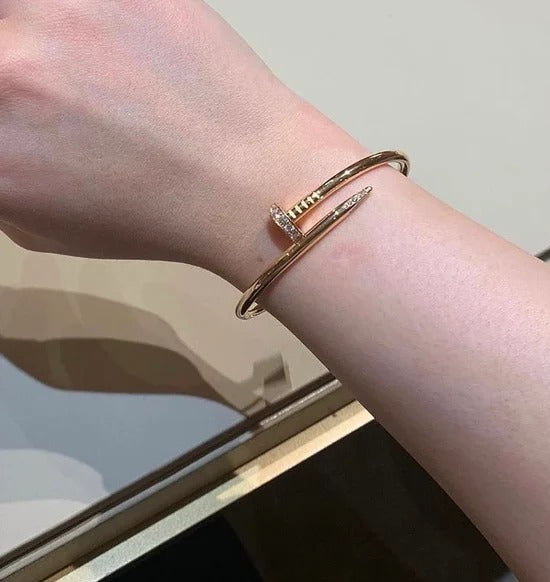 Rose gold bracelet on a wrist with a neutral background