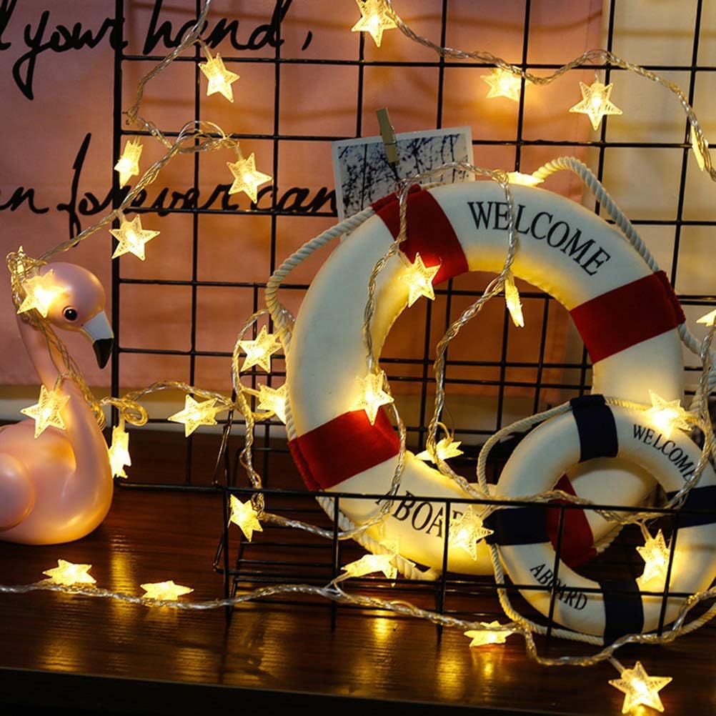 Decorative life buoy with string lights and a flamingo toy on a wooden surface.